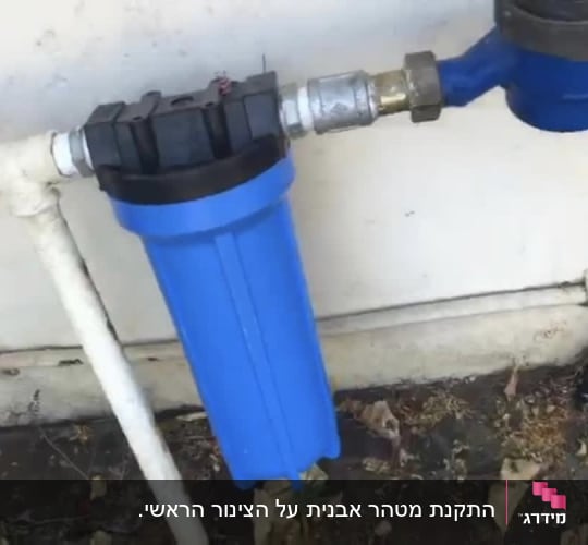 מסנן מים כחול מחובר לצינור לבן